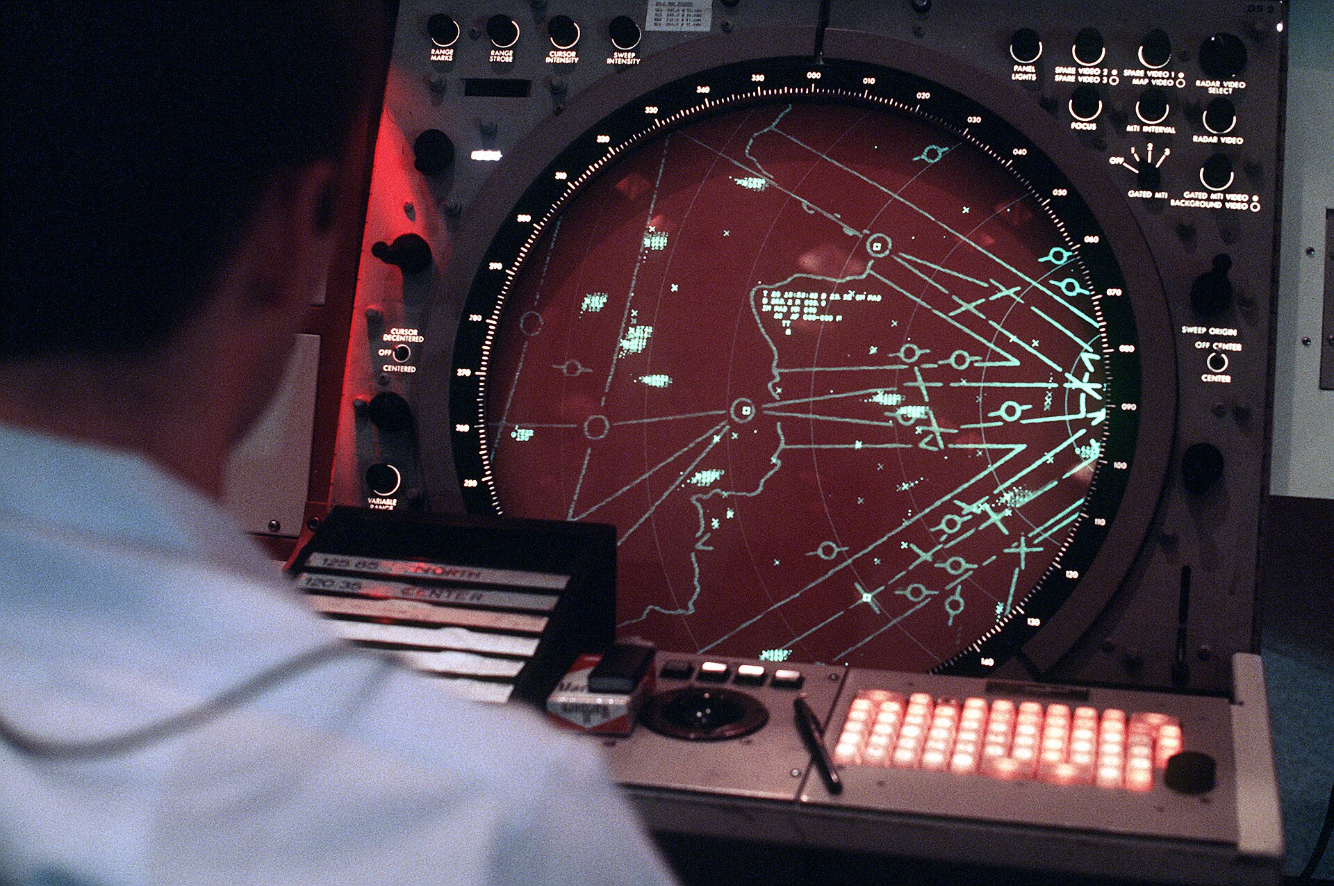 Air defense radar tracking console showing aircraft positions on a circular display screen. Photo: US Military / Public Domain