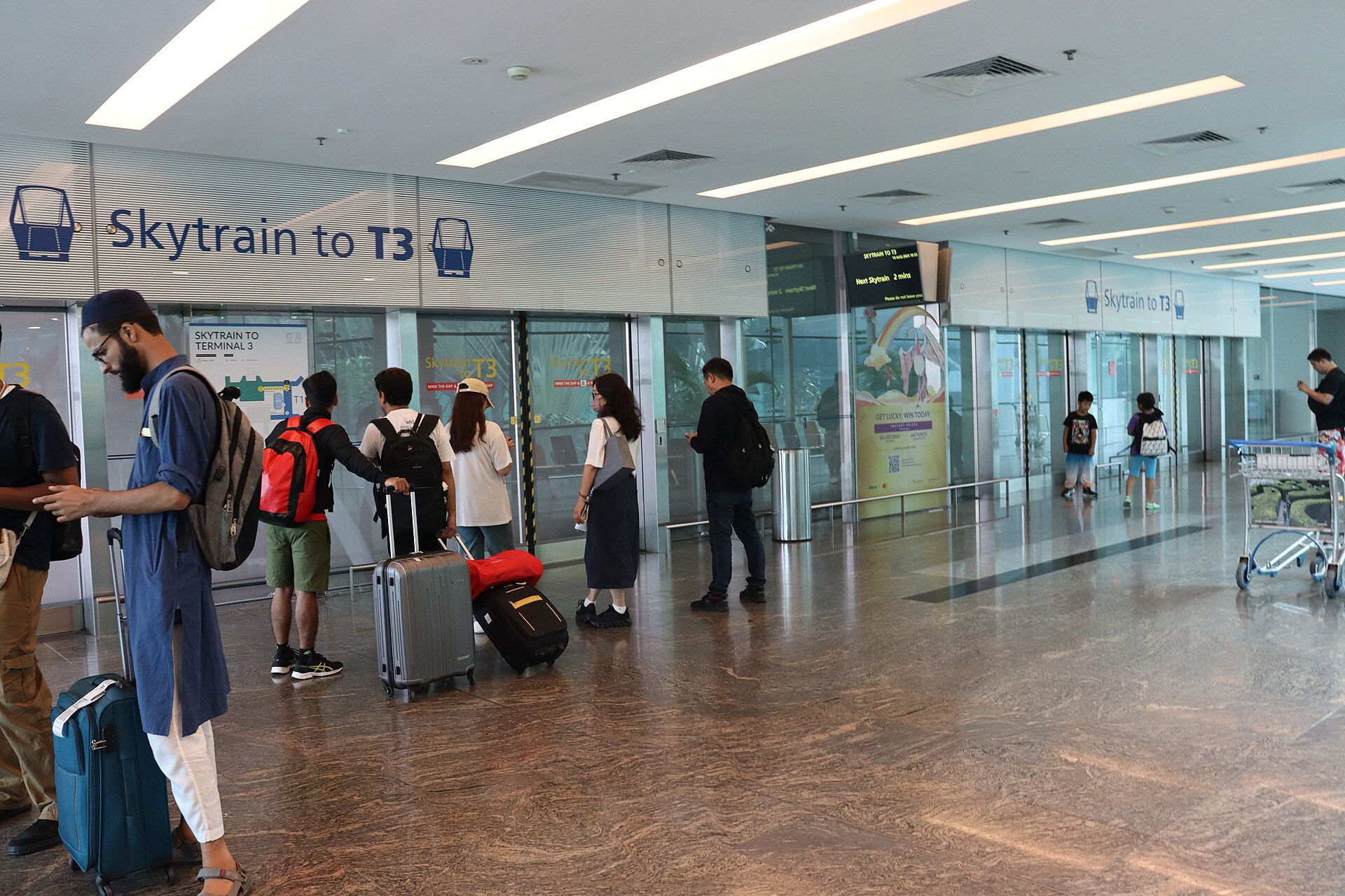 Passengers waiting with luggage at an international airport terminal as flight disruptions strand millions across the Gulf