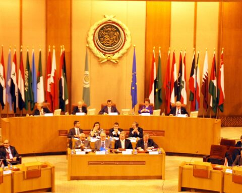 Arab League foreign ministers meeting in the main hall of the Arab League headquarters in Cairo, with member state flags and the organization emblem visible. Photo: European External Action Service / CC BY 2.0