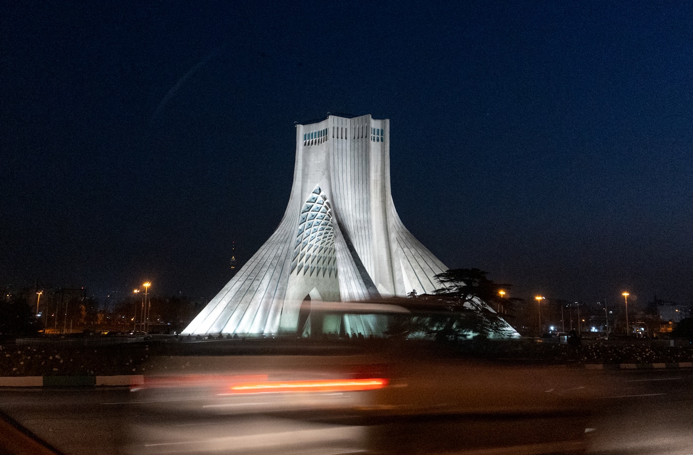 The Azadi Tower in Tehran illuminated at night, a symbol of Iran national identity and the seat of political power now divided between its elected president and Supreme Leader