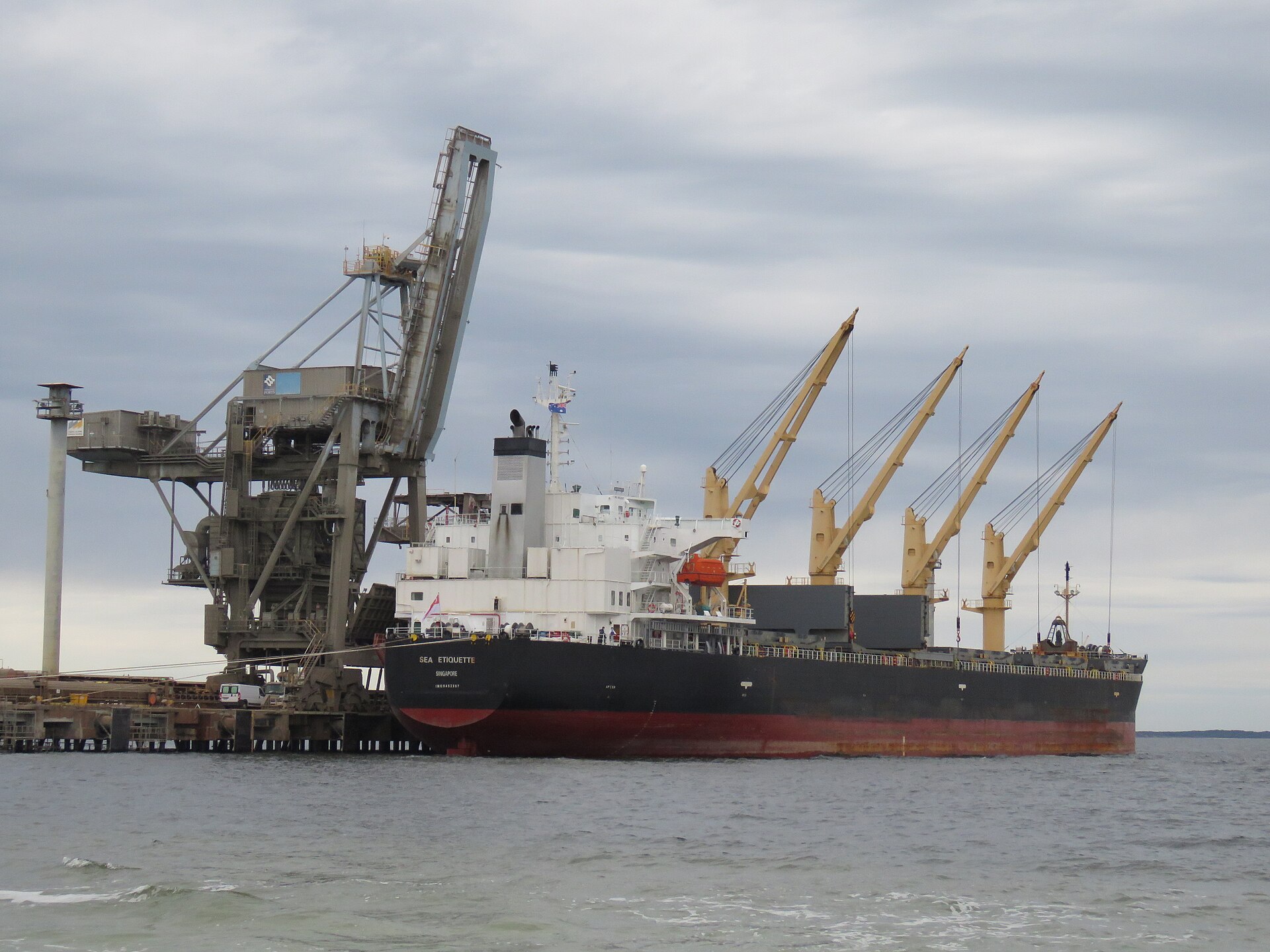 A bulk carrier docked at a maritime terminal, similar to the Thailand-flagged Mayuree Naree struck by IRGC projectiles in the Strait of Hormuz