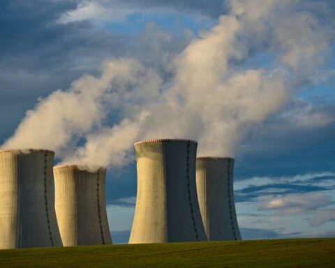 Nuclear power plant cooling towers releasing steam, representing the threat posed by Iran Bushehr reactor to Gulf states during the 2026 war