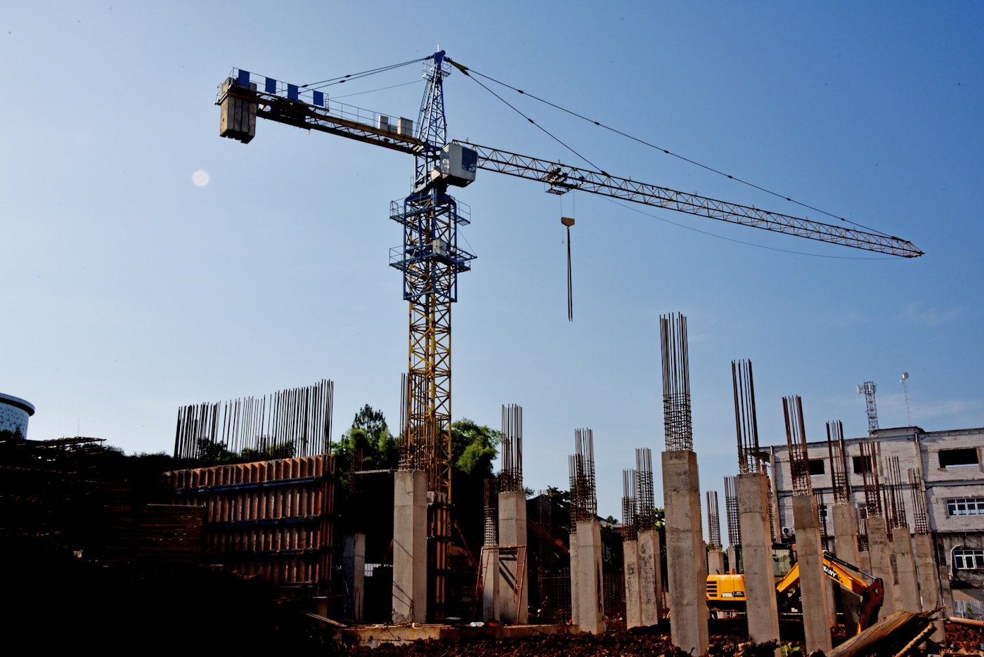 Construction crane and concrete pillars at a major building site representing the scale of infrastructure rebuilding required in post-war Iran