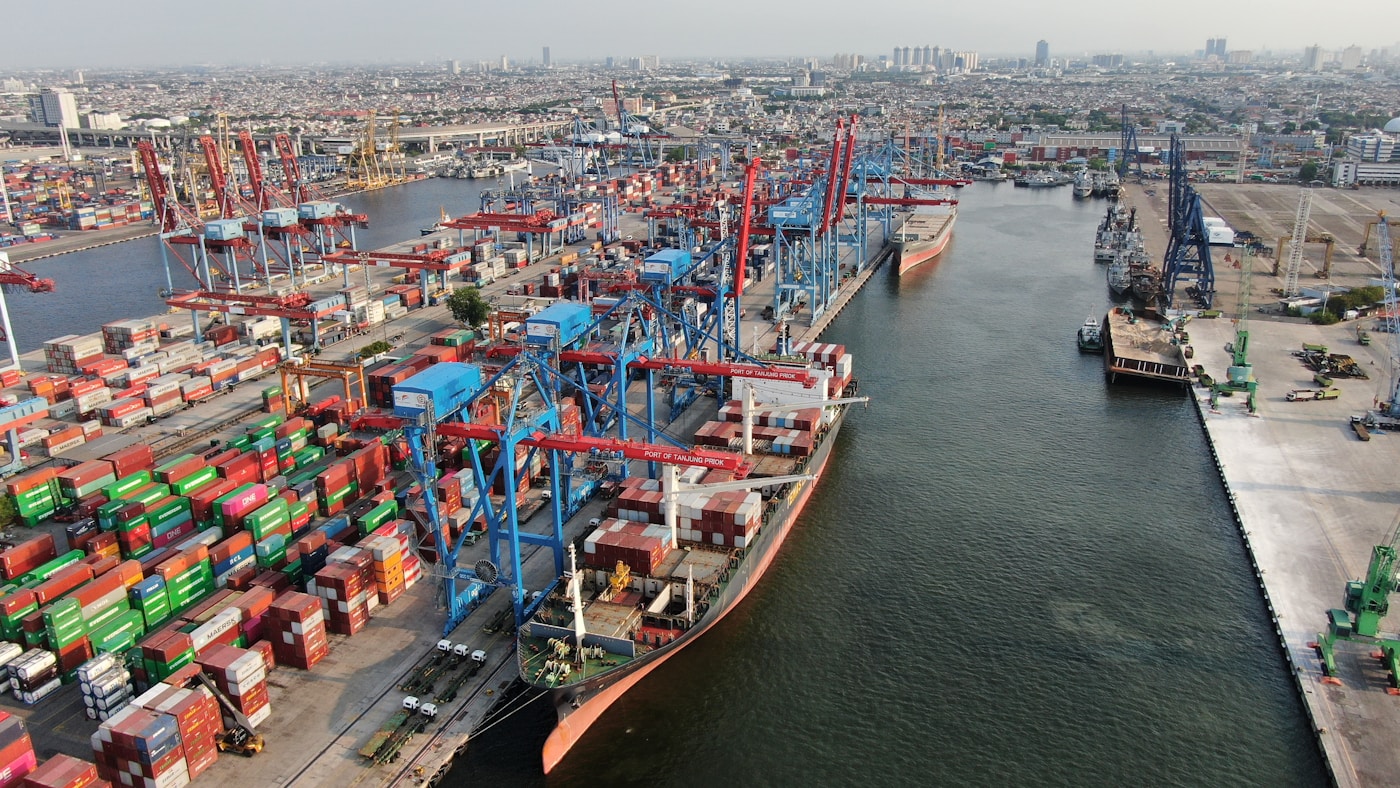 Busy container port with shipping cranes loading cargo ships, representing Belt and Road Initiative trade infrastructure connecting China to the Middle East