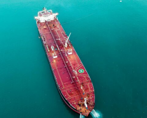 Aerial view of a crude oil supertanker transiting open waters, representing the Strait of Hormuz oil trade and petrodollar system