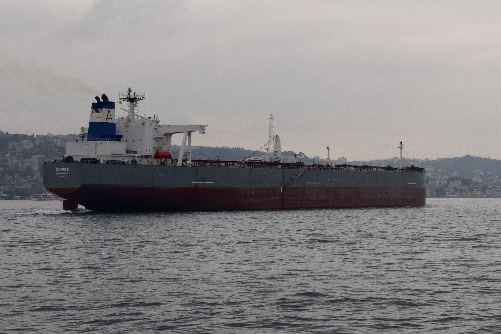 A crude oil tanker transits a narrow shipping strait, representing the maritime insurance crisis that has effectively sealed the Strait of Hormuz during the 2026 Iran war. Photo: Wikimedia Commons / CC BY-SA 4.0