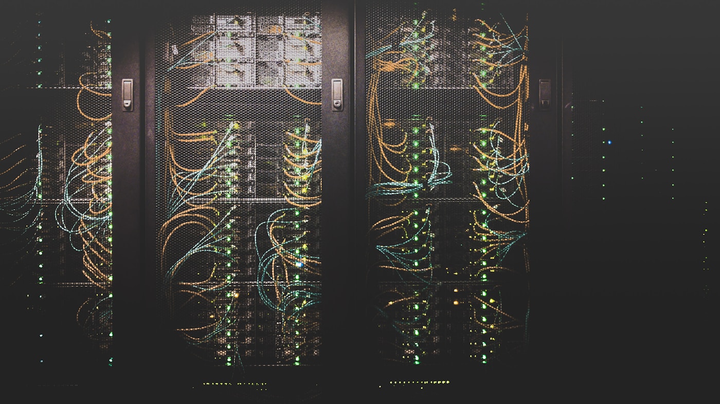 Server racks in a modern data center with fiber optic cables and LED lights, representing Saudi Arabia investment in artificial intelligence infrastructure including the 2.7 billion dollar Hexagon data center project.
