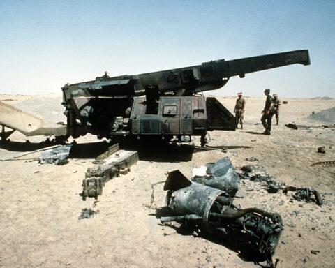 Destroyed missile launcher system in desert wreckage after military airstrike, representing the dismantlement of Iran military-industrial complex. Photo: US Department of Defense / Public Domain