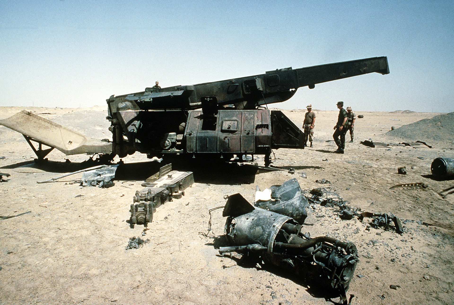 Destroyed missile launcher system in desert wreckage after military airstrike, representing the dismantlement of Iran military-industrial complex. Photo: US Department of Defense / Public Domain