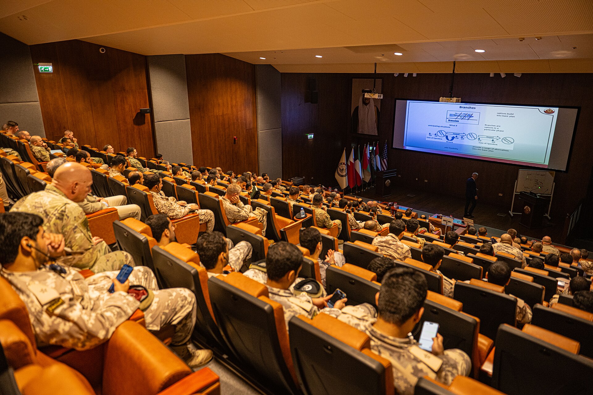 US and Gulf Cooperation Council military personnel from multiple nations attend joint operations planning during Exercise Eagle Resolve 2025, with GCC national flags displayed