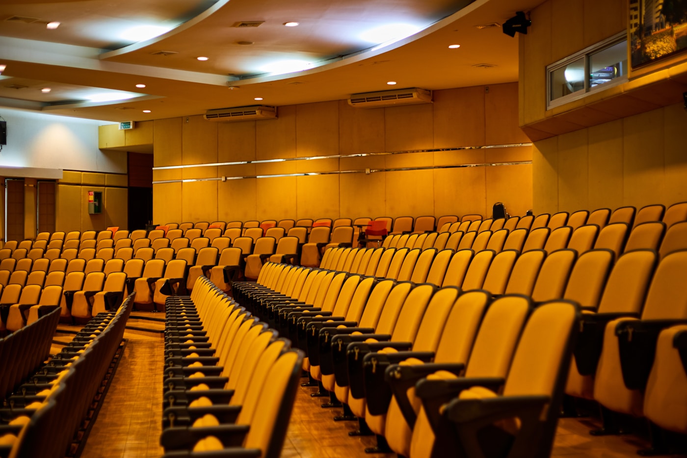Empty auditorium with rows of vacant seats representing Gulf conference industry collapse during Iran war