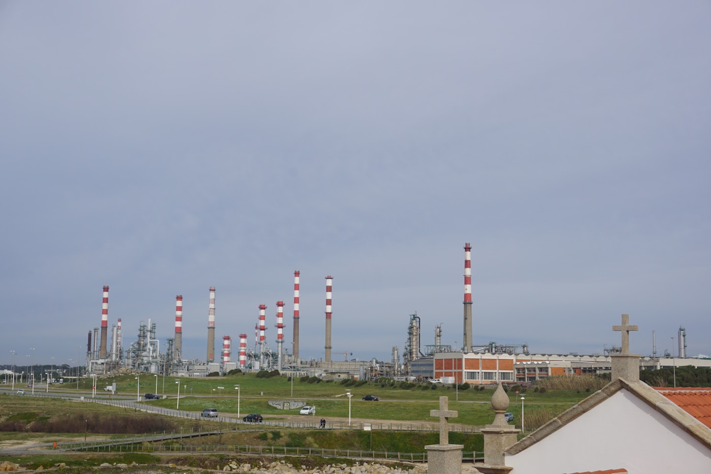 European oil refinery with industrial chimneys, representing the energy infrastructure facing supply disruption from the Iran war Hormuz blockade