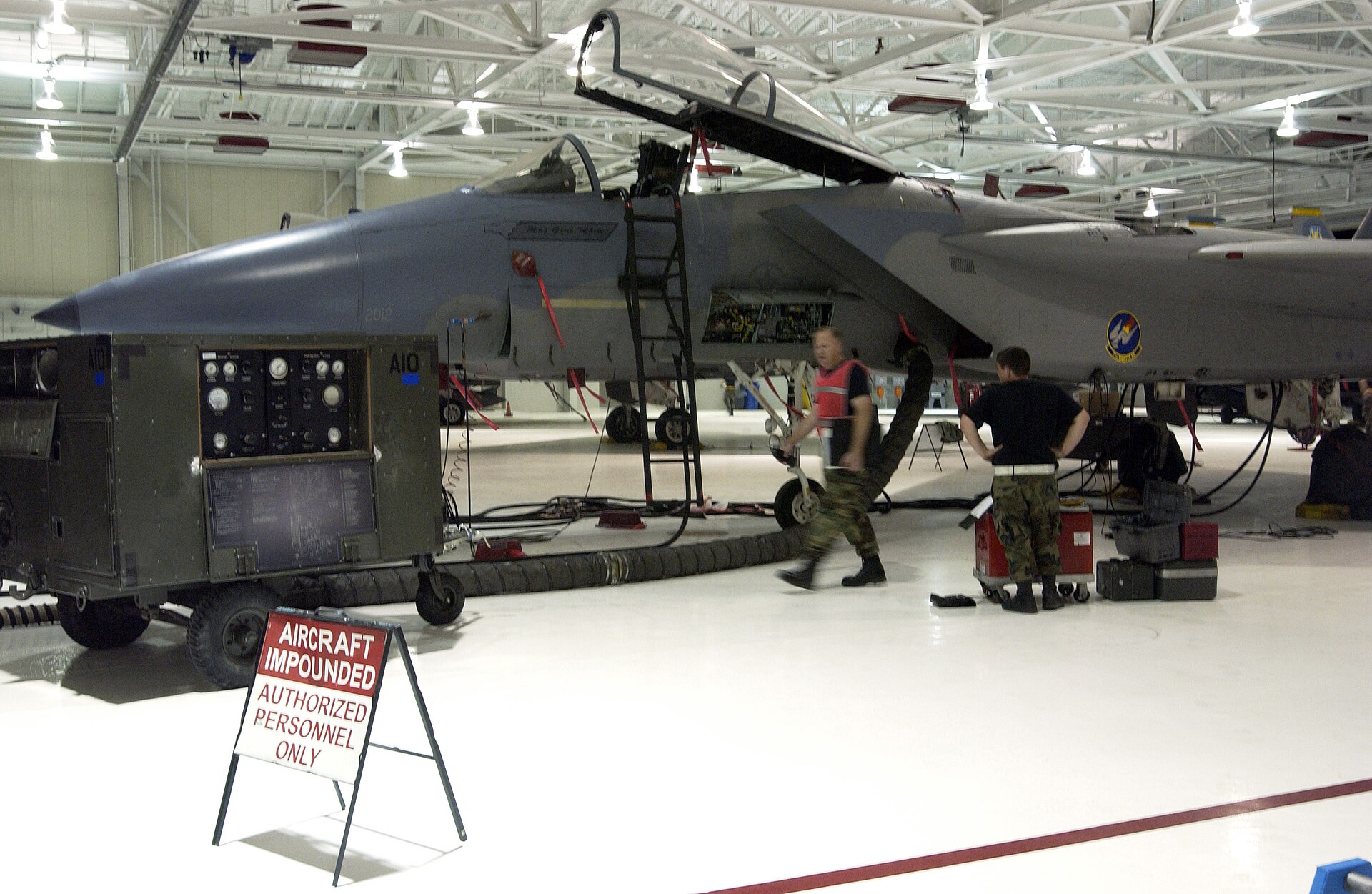 Airmen performing advanced maintenance on an F-15 Eagle fighter aircraft inside a military hangar, illustrating the domestic defense manufacturing capabilities Saudi Arabia is building through SAMI