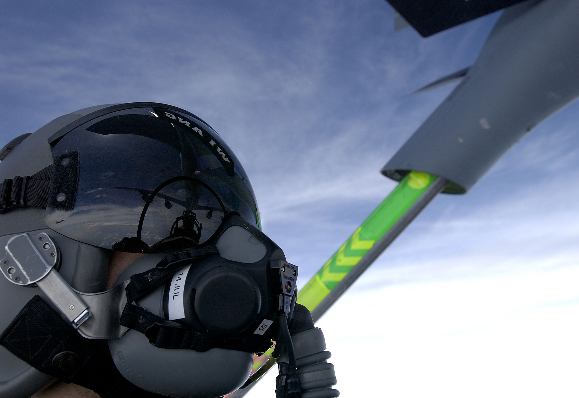 A fighter pilot helmet visor reflects the refueling boom of a KC-135 Stratotanker during an aerial refueling mission. Photo: U.S. Air Force / Public Domain