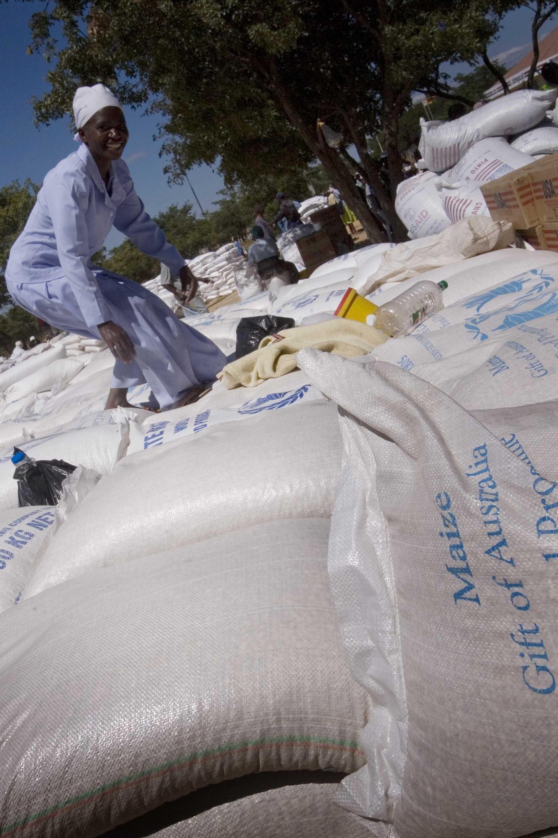 Woman stacking bags of food aid at a World Food Programme distribution point in Africa, where fertilizer shortages from the Iran war threaten to push 45 million more people into hunger