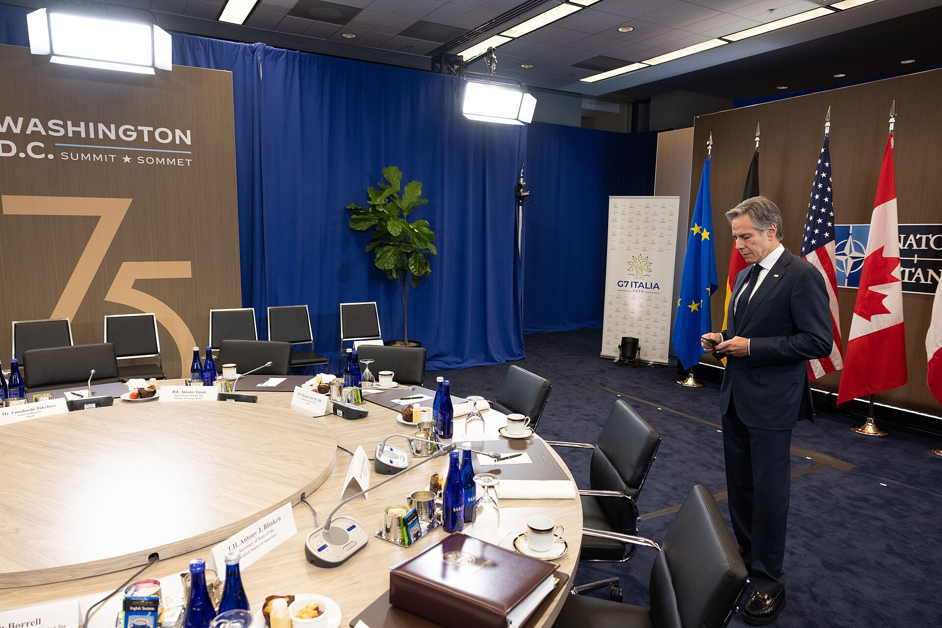 G7 foreign ministers meeting room with round diplomatic table and national flags, representing the March 2026 summit in France on the Iran war. Photo: US State Department / Public Domain