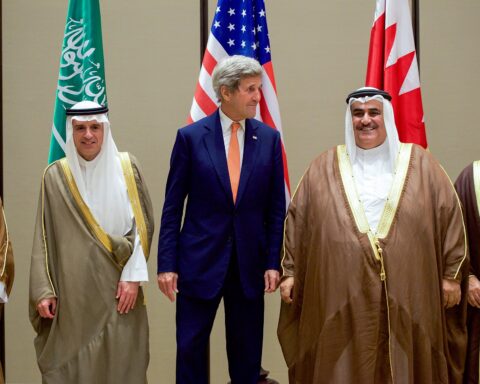 Gulf Cooperation Council foreign ministers standing together at a GCC ministerial meeting in Manama, Bahrain, with member state flags