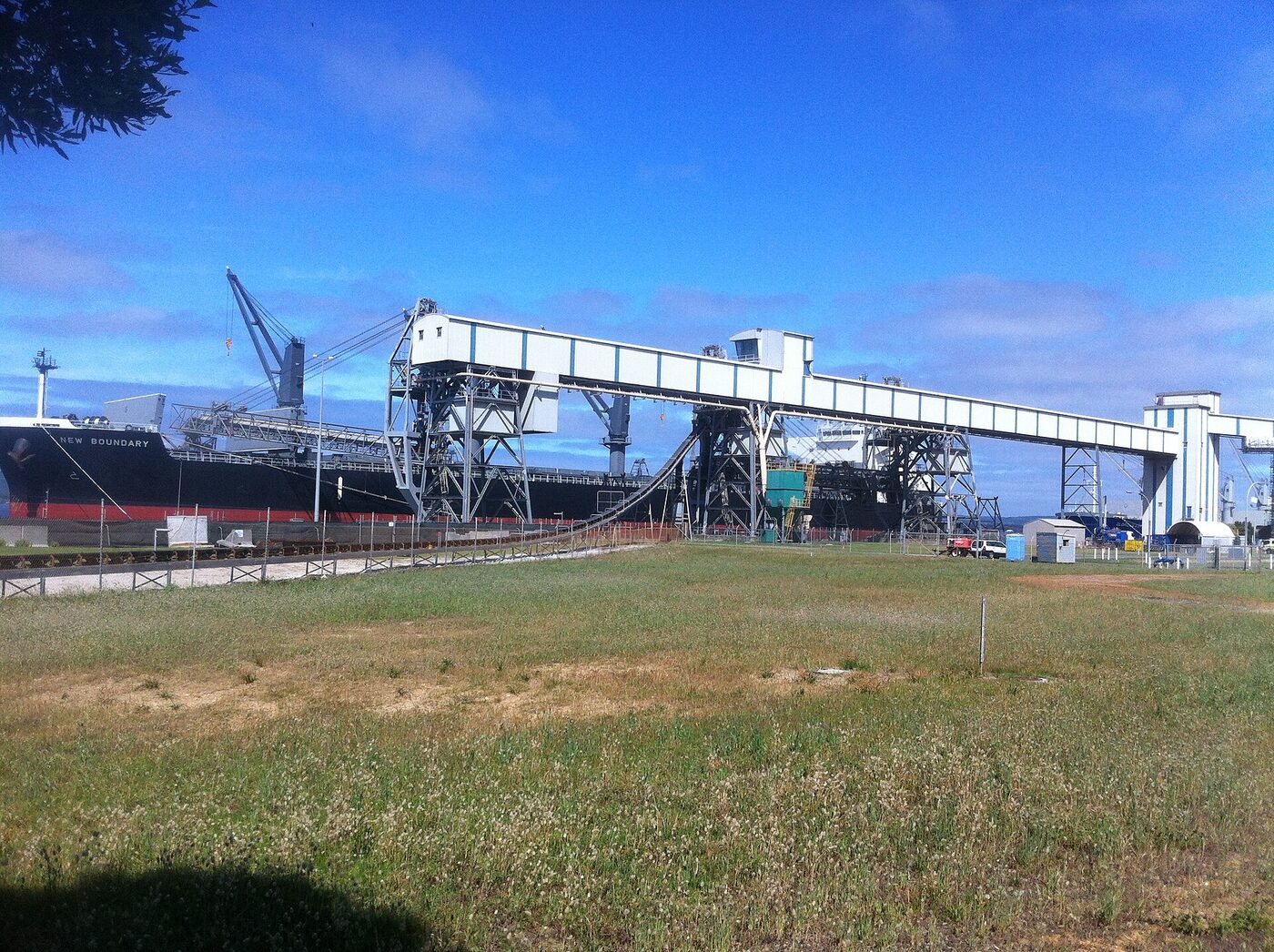 Bulk grain carrier being loaded at port — Saudi Arabia imports over 80 percent of its food by sea through routes now disrupted by the Iran war. Photo: Wikimedia Commons / CC BY-SA 4.0
