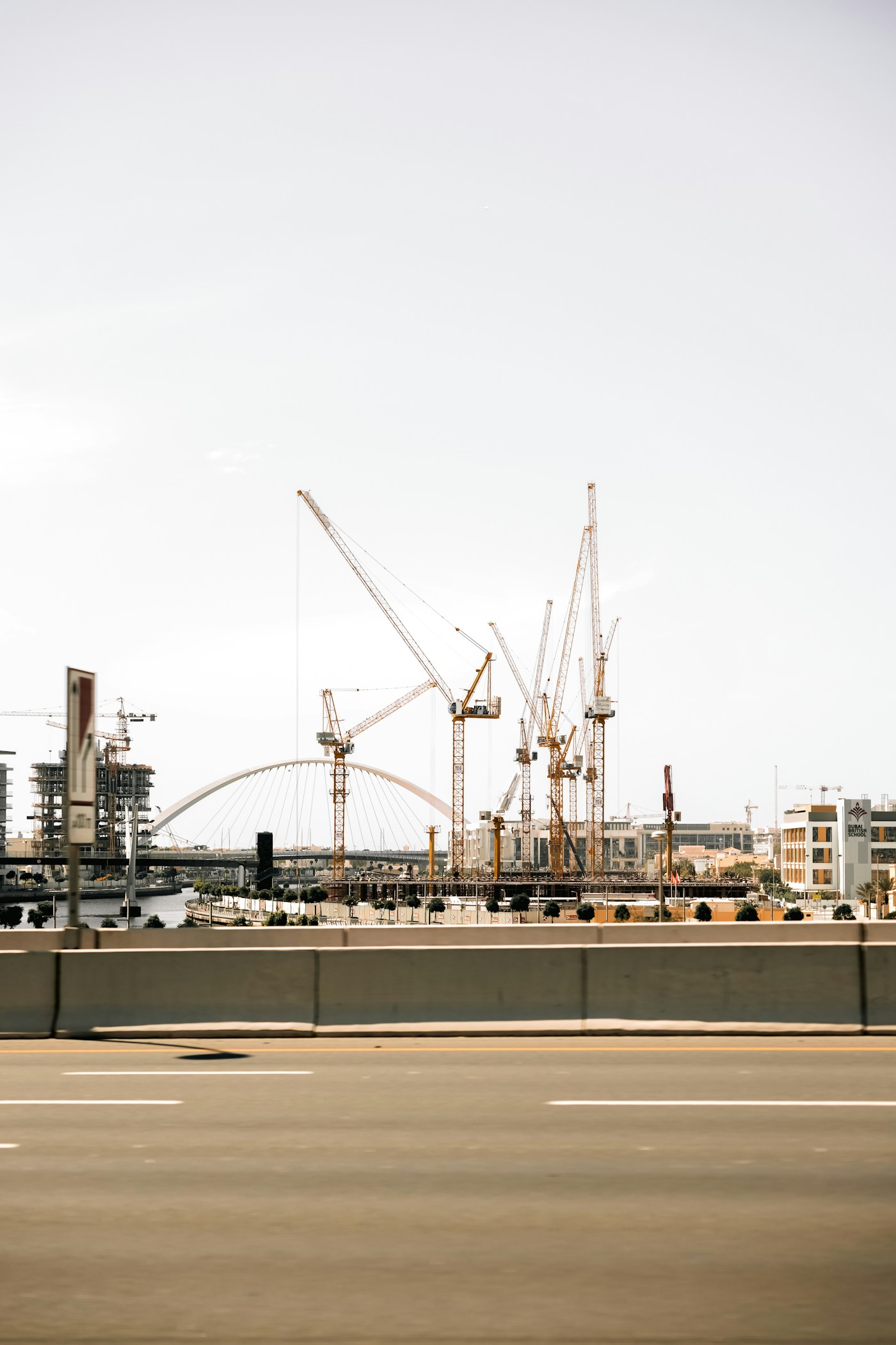 Construction cranes dominate a Gulf city skyline, representing the massive building projects now threatened by the Iran war and capital flight from Saudi Arabia