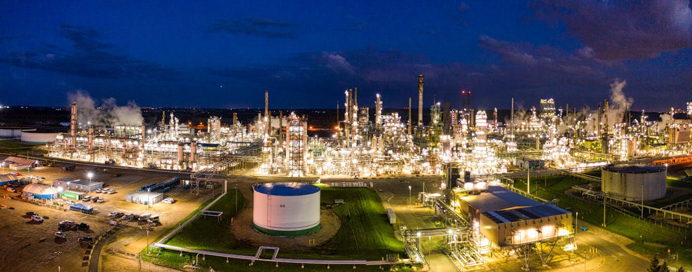Panoramic view of oil refinery and storage tanks at dusk showing the scale of Gulf petrochemical infrastructure