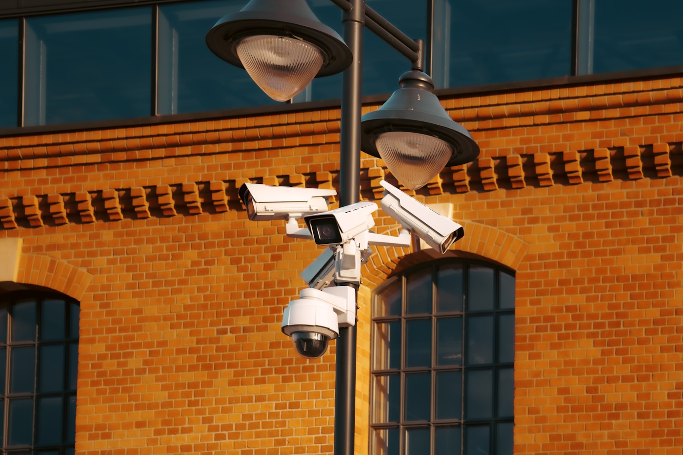 Surveillance cameras mounted on an urban lamp post representing the Gulf states expanded internal security monitoring during the Iran war