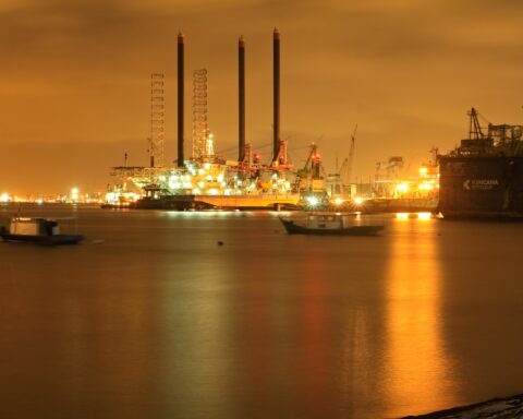 Oil and petroleum infrastructure at a coastal port terminal at night, representing the Saudi oil facilities Iran denies attacking during the 2026 war