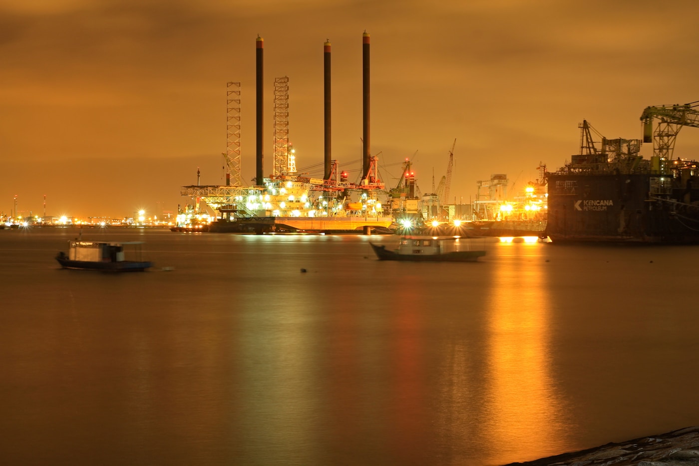 Oil and petroleum infrastructure at a coastal port terminal at night, representing the Saudi oil facilities Iran denies attacking during the 2026 war