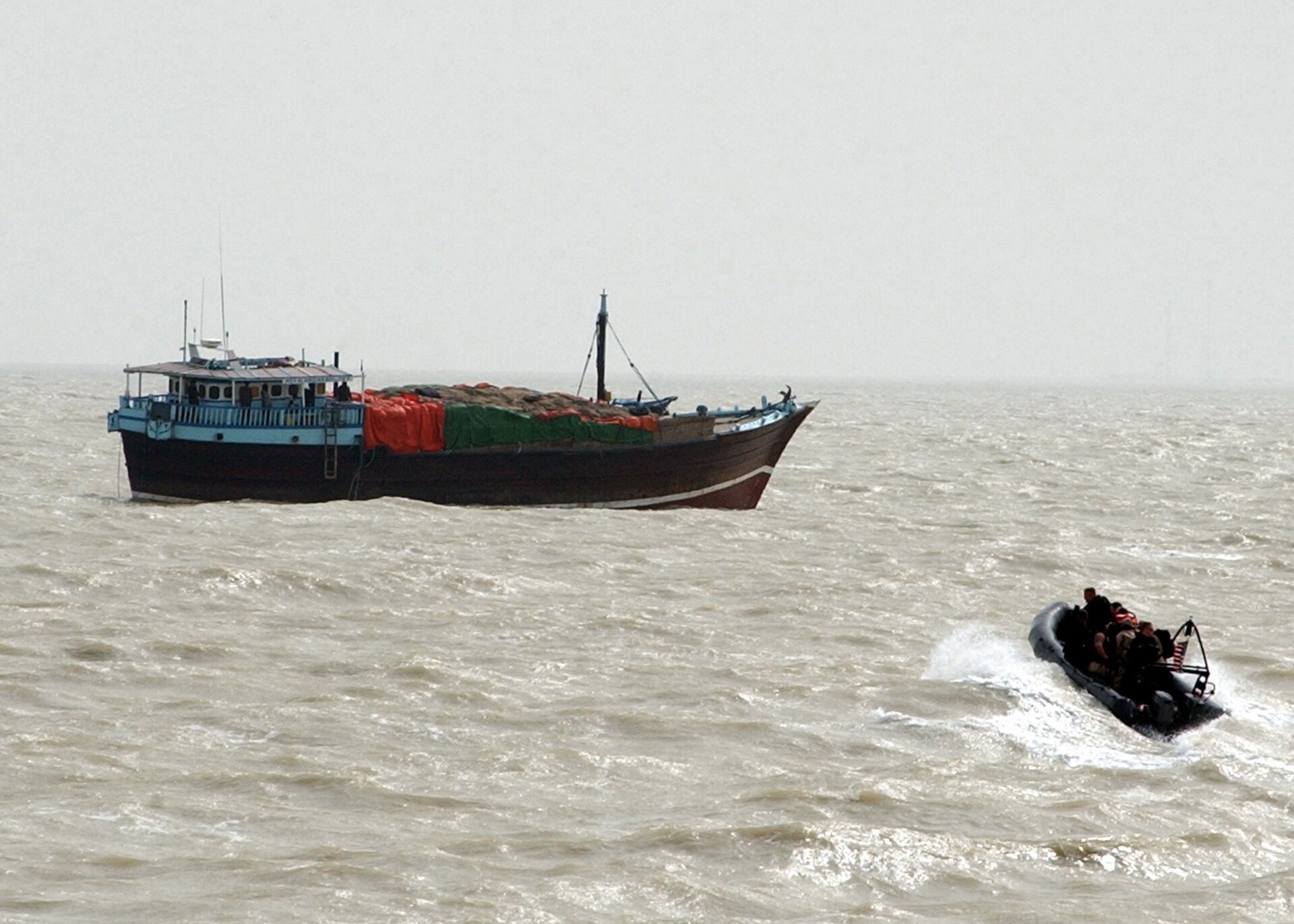 Naval boarding team approaches a cargo vessel in the Arabian Gulf as Iran imposes transit fees on Strait of Hormuz shipping. Photo: US Navy / Public Domain