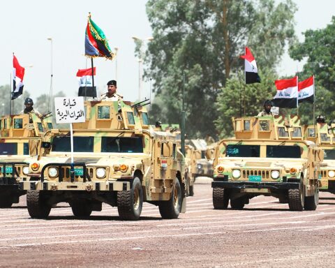 Iraqi army military vehicles during a parade in Baghdad, with soldiers manning Humvees flying Iraqi flags. Photo: US Army / Public Domain