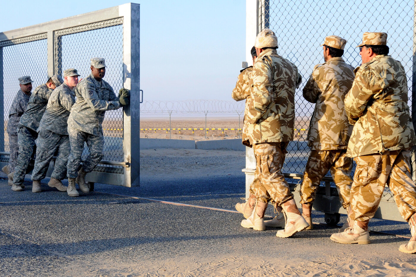 American and Kuwaiti soldiers close the border gate between Iraq and Kuwait, a reminder of the volatile security dynamics along the Gulf states northern frontier. Photo: U.S. Department of Defense / Public Domain