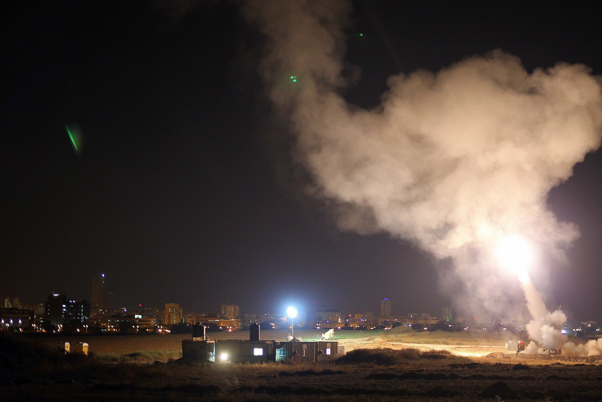 Iron Dome missile defense system intercepting rockets over an Israeli city at night, with trails of light visible against the dark sky. Photo: IDF / Wikimedia Commons / CC BY 2.0