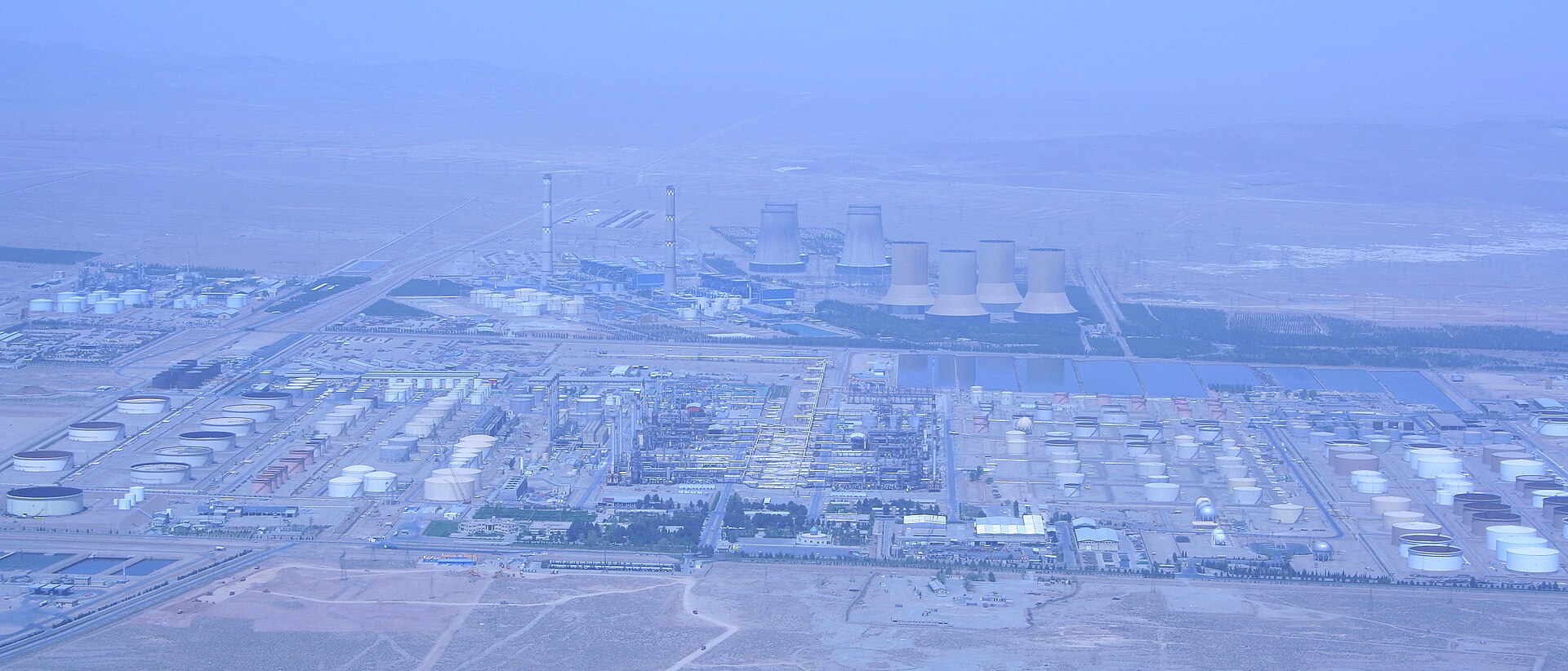 Aerial view of Isfahan oil refinery and thermal power station in Iran showing petroleum storage tanks, cooling towers, and industrial infrastructure