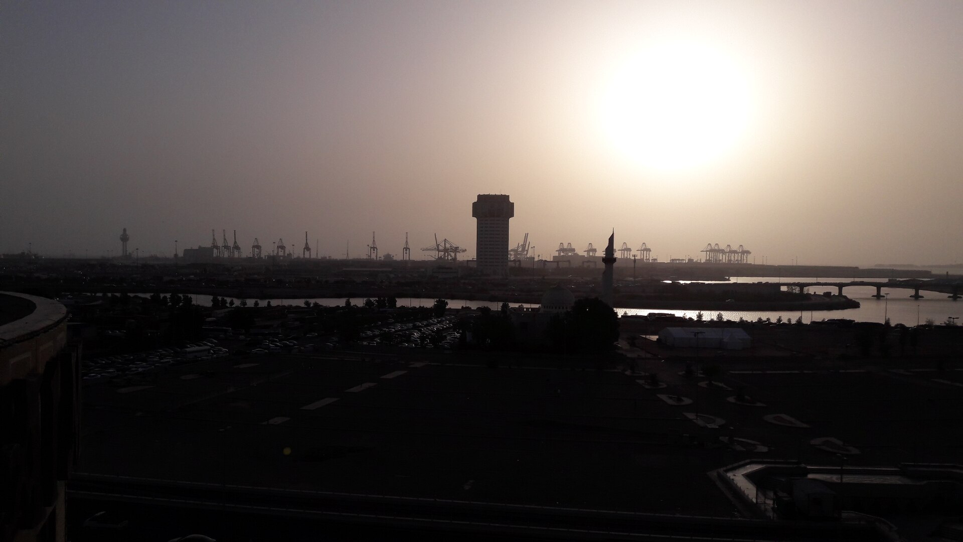 Jeddah Islamic Port at sunset with container cranes and port control tower silhouetted against the sky. Photo: Wikimedia Commons / CC BY-SA 4.0