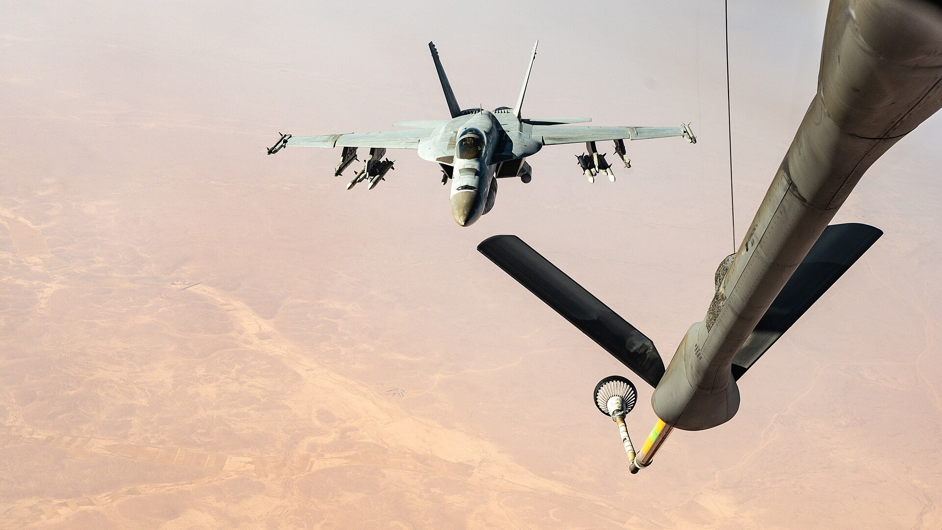 A KC-135 Stratotanker conducts aerial refueling of a Navy fighter jet over the Middle East during CENTCOM operations. Photo: U.S. Air Force / Public Domain