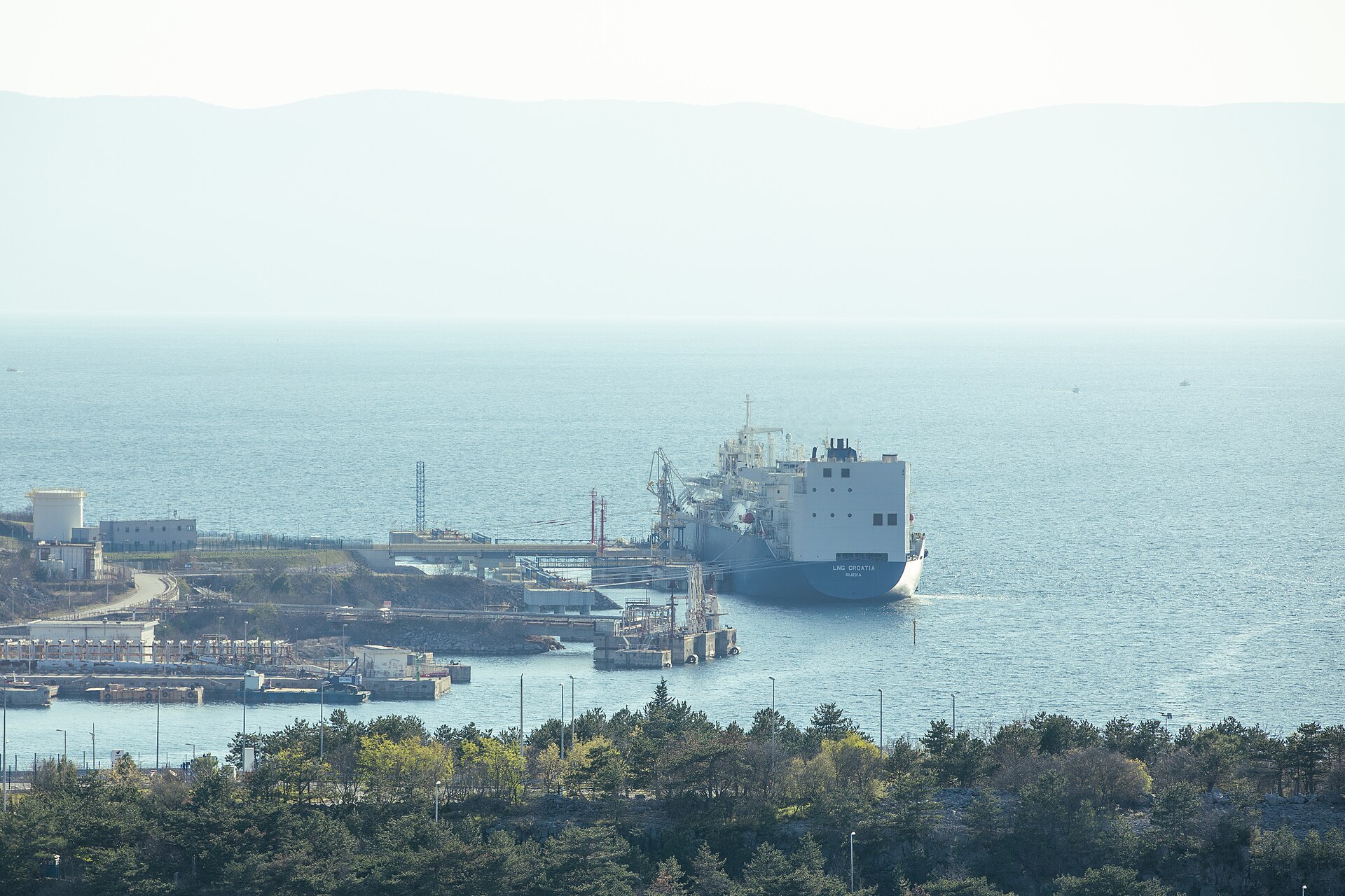 An LNG tanker docked at an energy export terminal, the type of vessel affected by the Strait of Hormuz blockade. Photo: Wikimedia Commons / CC BY 2.0
