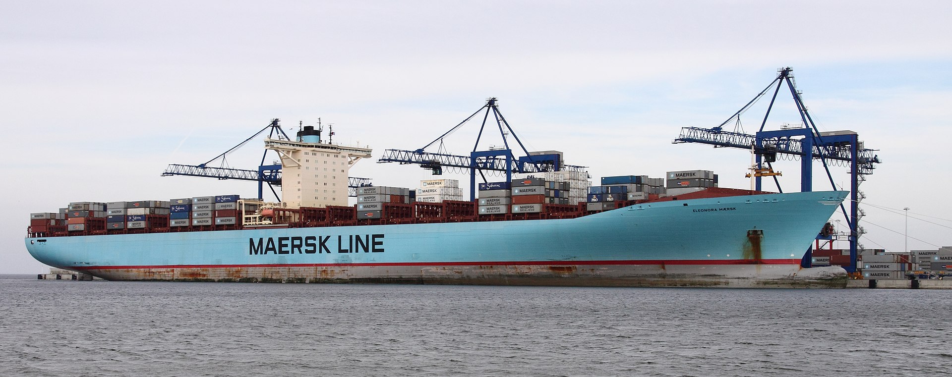 Maersk Line container vessel being loaded at port. Major carriers including Maersk, CMA CGM, and Hapag-Lloyd have suspended Hormuz transits. Photo: Wikimedia Commons / CC BY