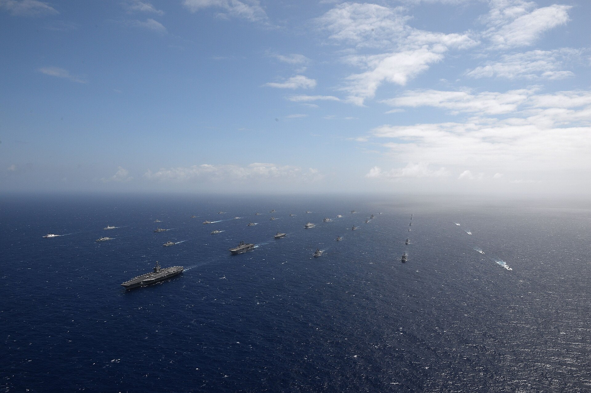 A multinational naval fleet steams in formation during a joint exercise. Trump has called on six nations to send warships to reopen the Strait of Hormuz. Photo: U.S. Navy / Public Domain