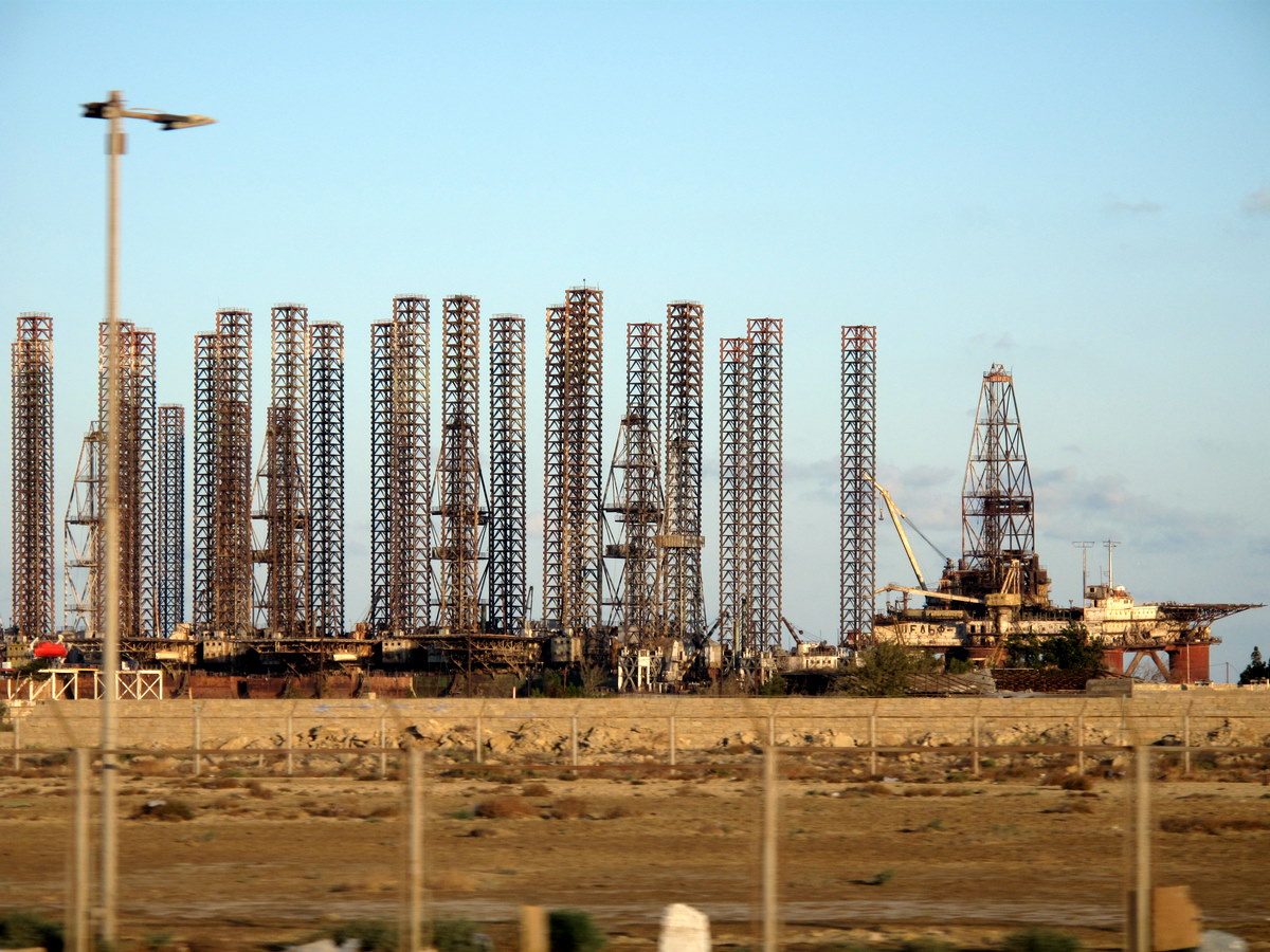 Multiple offshore jackup drilling rigs stacked in a yard, representative of the platforms suspended by Arabian Drilling and ADES amid Iran war safety concerns. Photo: Wikimedia Commons / CC BY-SA 2.0