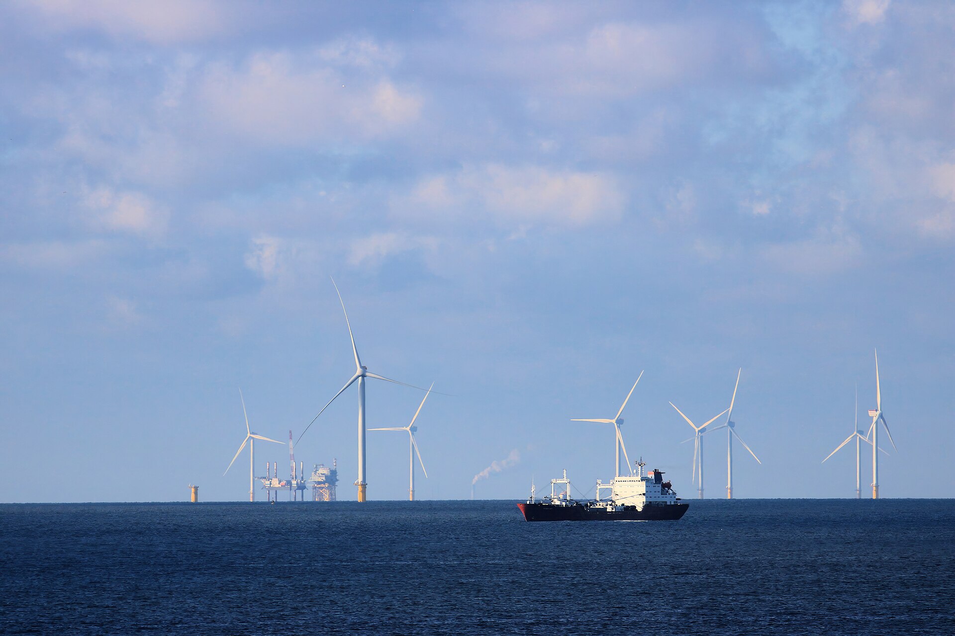 Oil tanker navigating open waters alongside energy infrastructure, illustrating the global maritime trade disrupted by the Strait of Hormuz blockade. Photo: Wikimedia Commons / CC BY 4.0