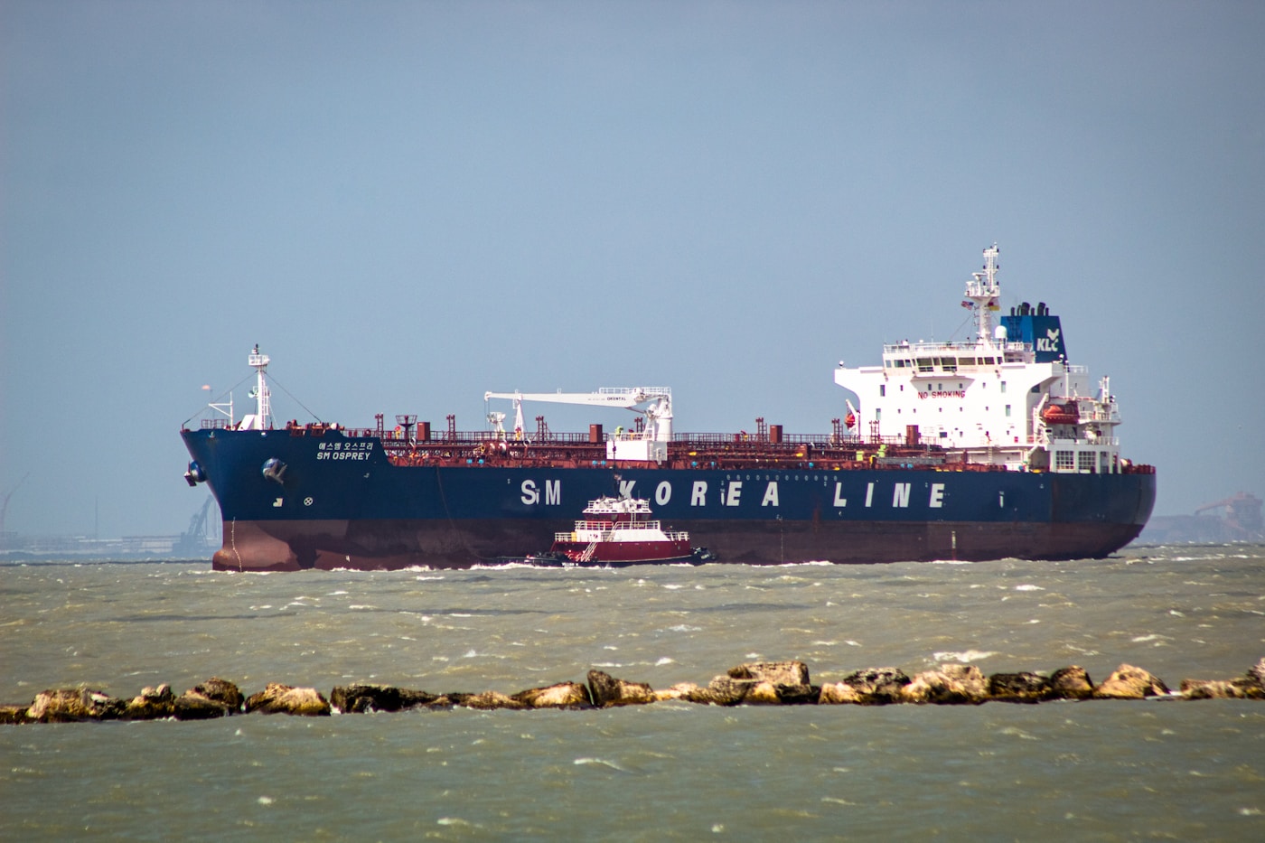 An oil tanker from SM Korea Line navigating open waters, illustrating the disruption to Asian oil shipping routes caused by the Strait of Hormuz closure