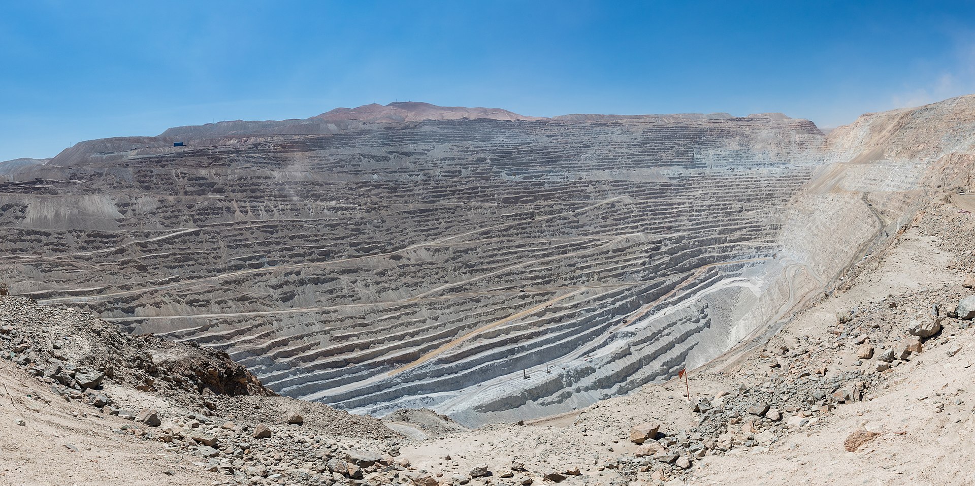 A vast open-pit copper mine in a desert landscape, showing the massive scale of modern mineral extraction operations similar to those planned for Saudi Arabia. Photo: Wikimedia Commons / CC BY-SA 4.0
