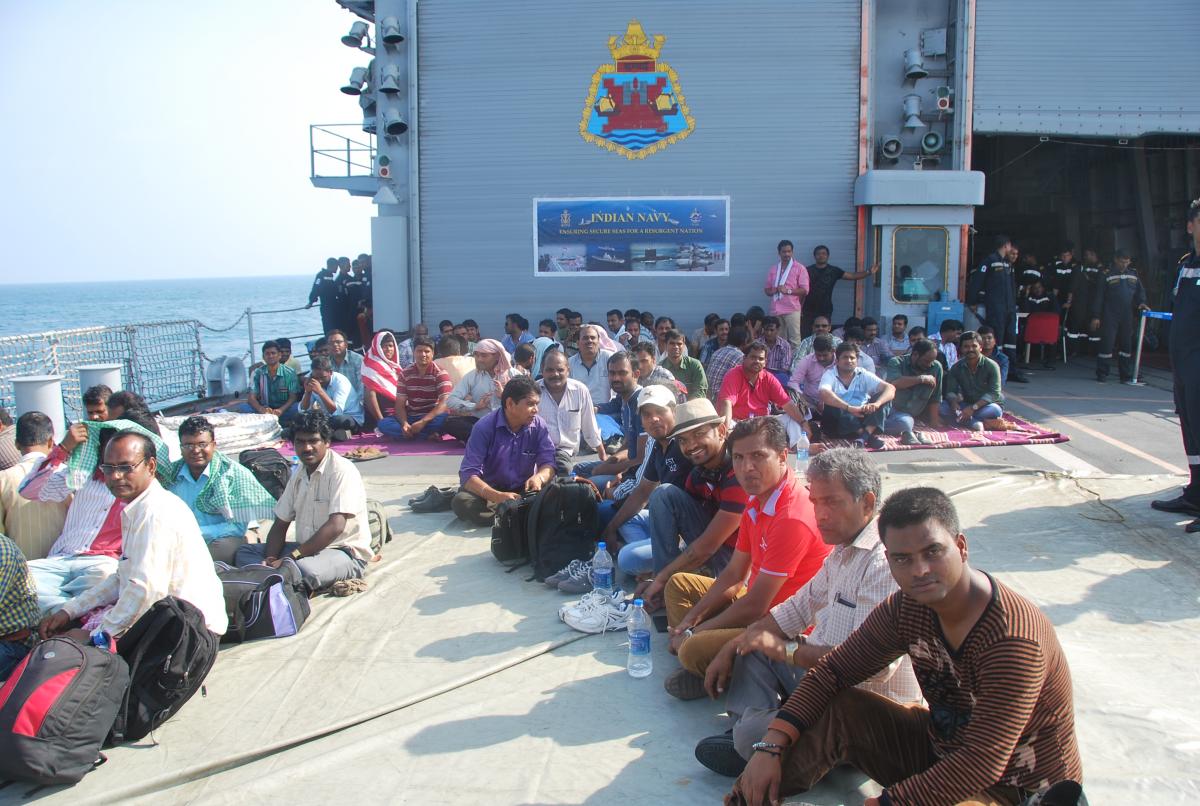 Indian and foreign nationals evacuated from Yemen wait on the helicopter deck of an Indian Navy warship during Operation Raahat, 2015