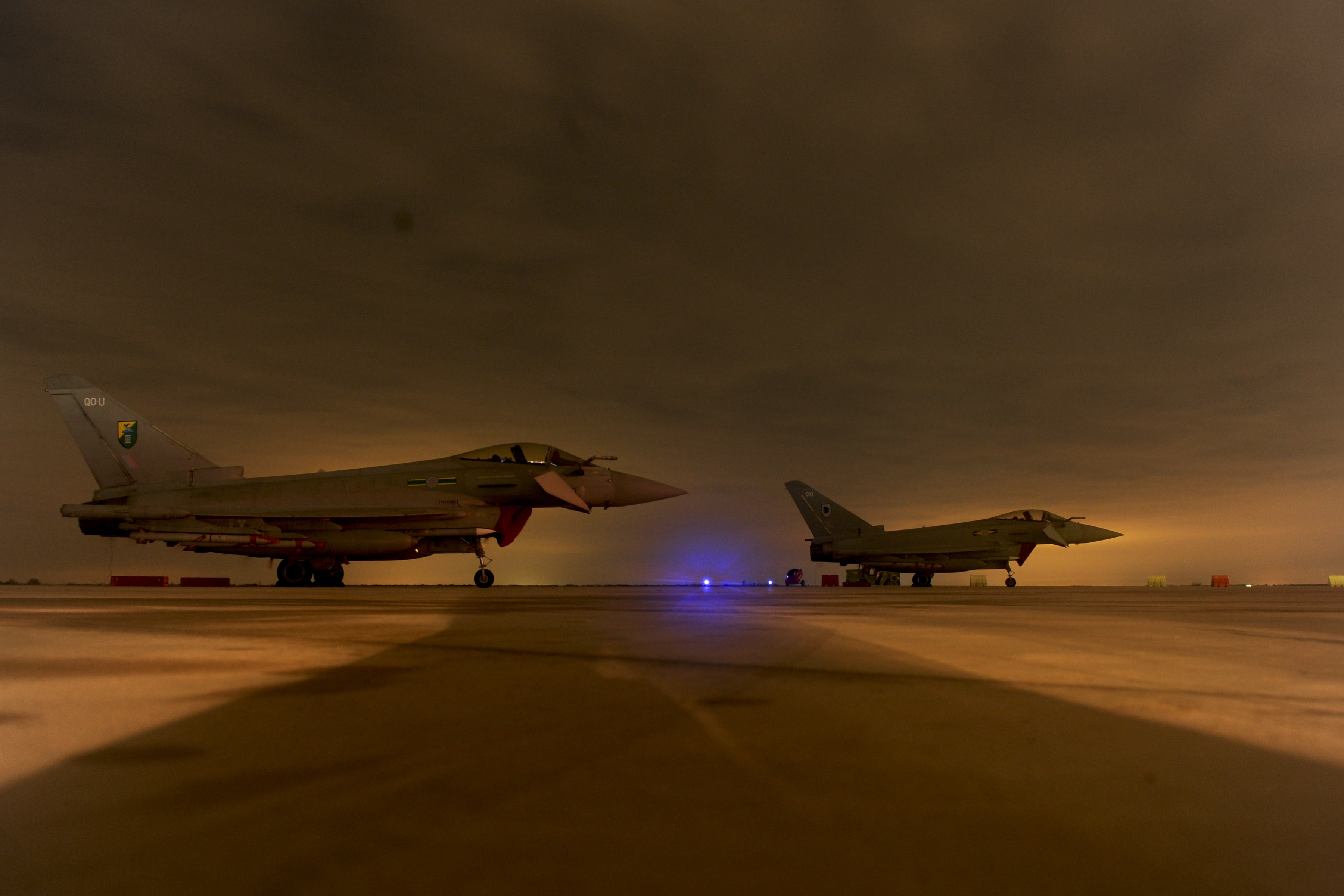 Two RAF Typhoon fighter jets on an operational airfield at night, ready for combat deployment in the Middle East. Photo: UK Ministry of Defence / OGL v1.0