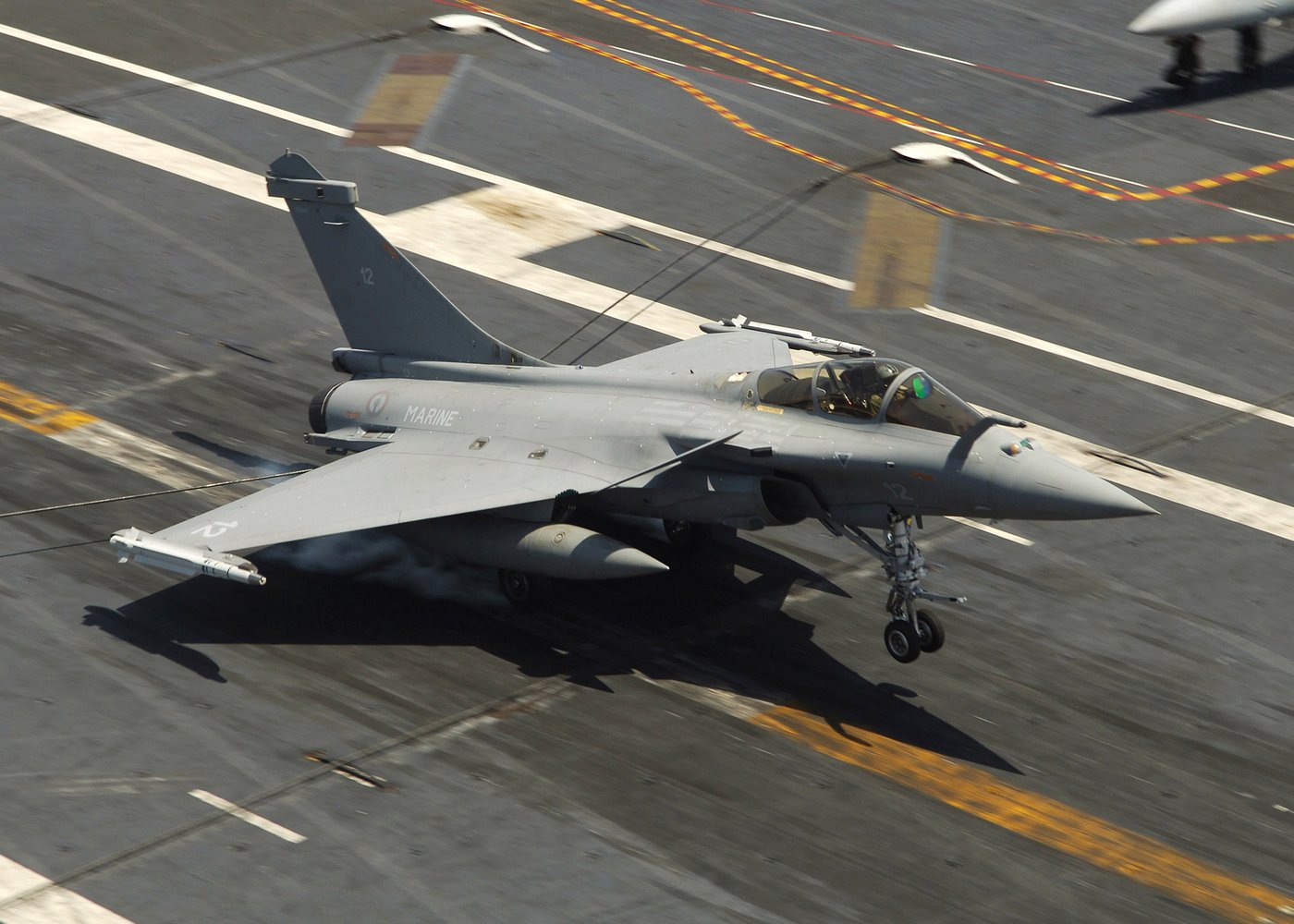 A French Navy Rafale M fighter aircraft lands on a carrier flight deck. The Charles de Gaulle carrier group carries 20 Rafale jets now deployed to the eastern Mediterranean. Photo: US Navy / Public Domain