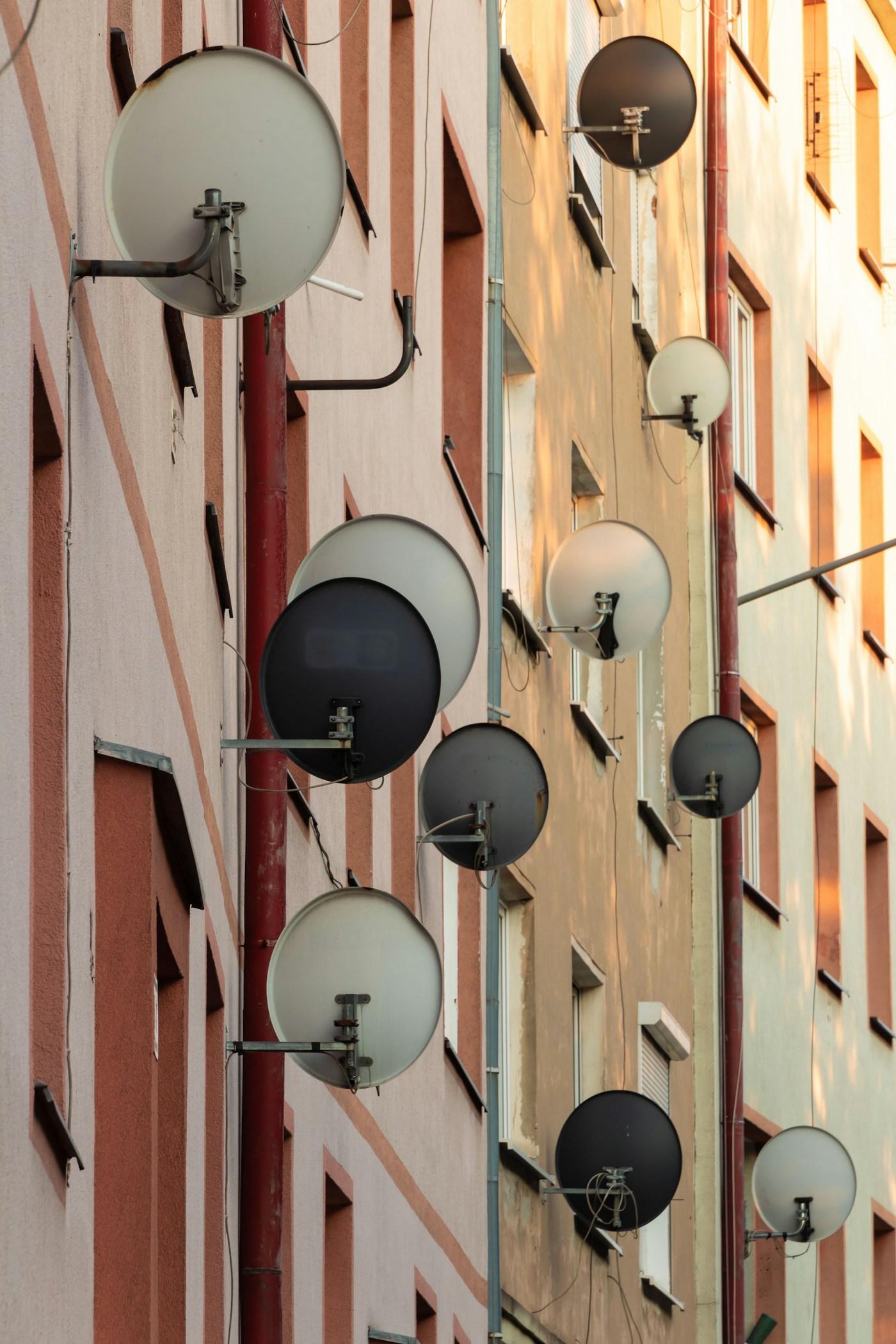 Satellite dishes on a residential building representing the broadcast infrastructure that carries competing narratives across the Middle East