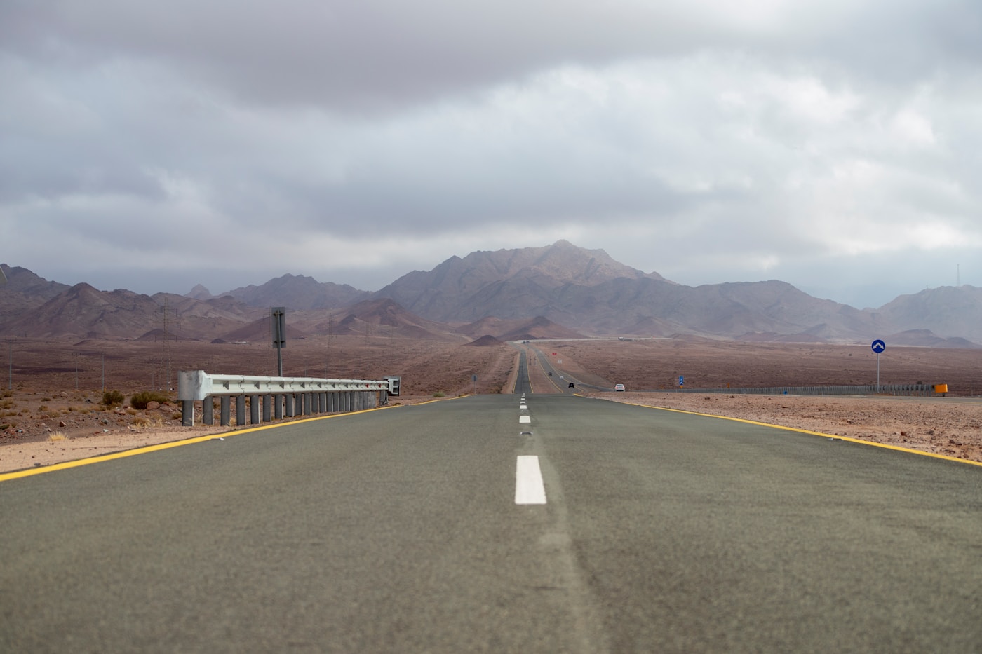 Desert highway in Saudi Arabia stretching toward mountains