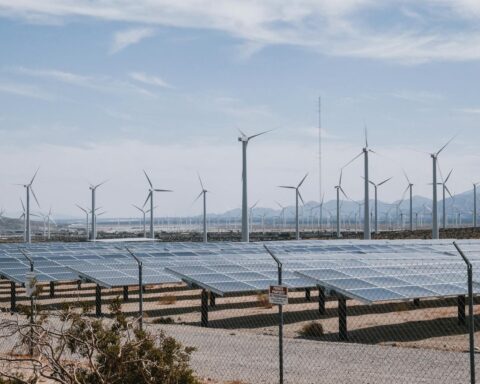 Solar panels and wind turbines in a desert landscape representing Saudi Arabia renewable energy expansion