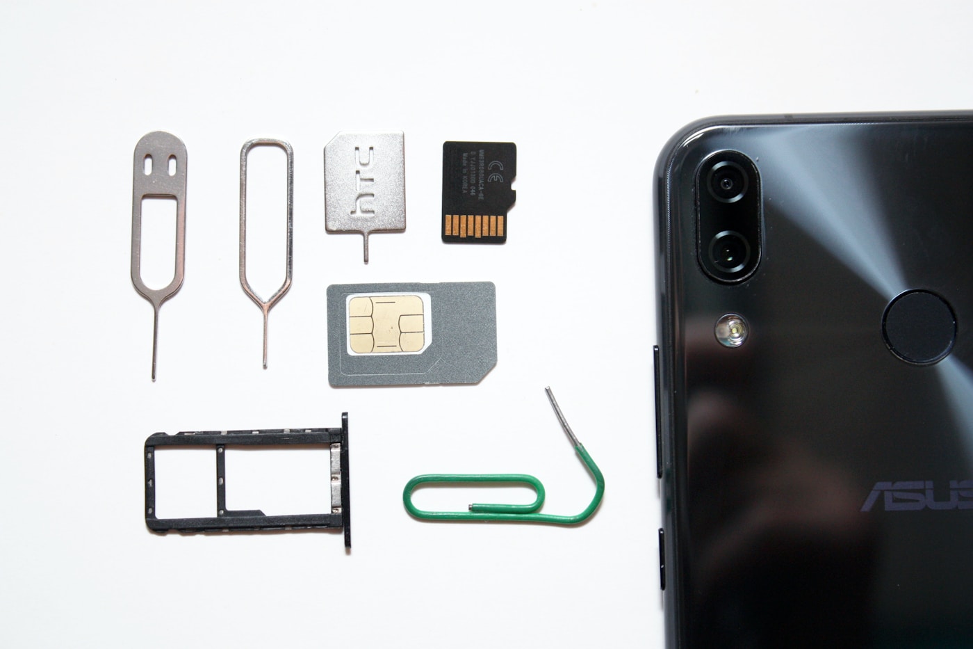 SIM card, smartphone, SIM tray and ejector tools laid out on a white surface for a Saudi Arabia travel SIM card guide