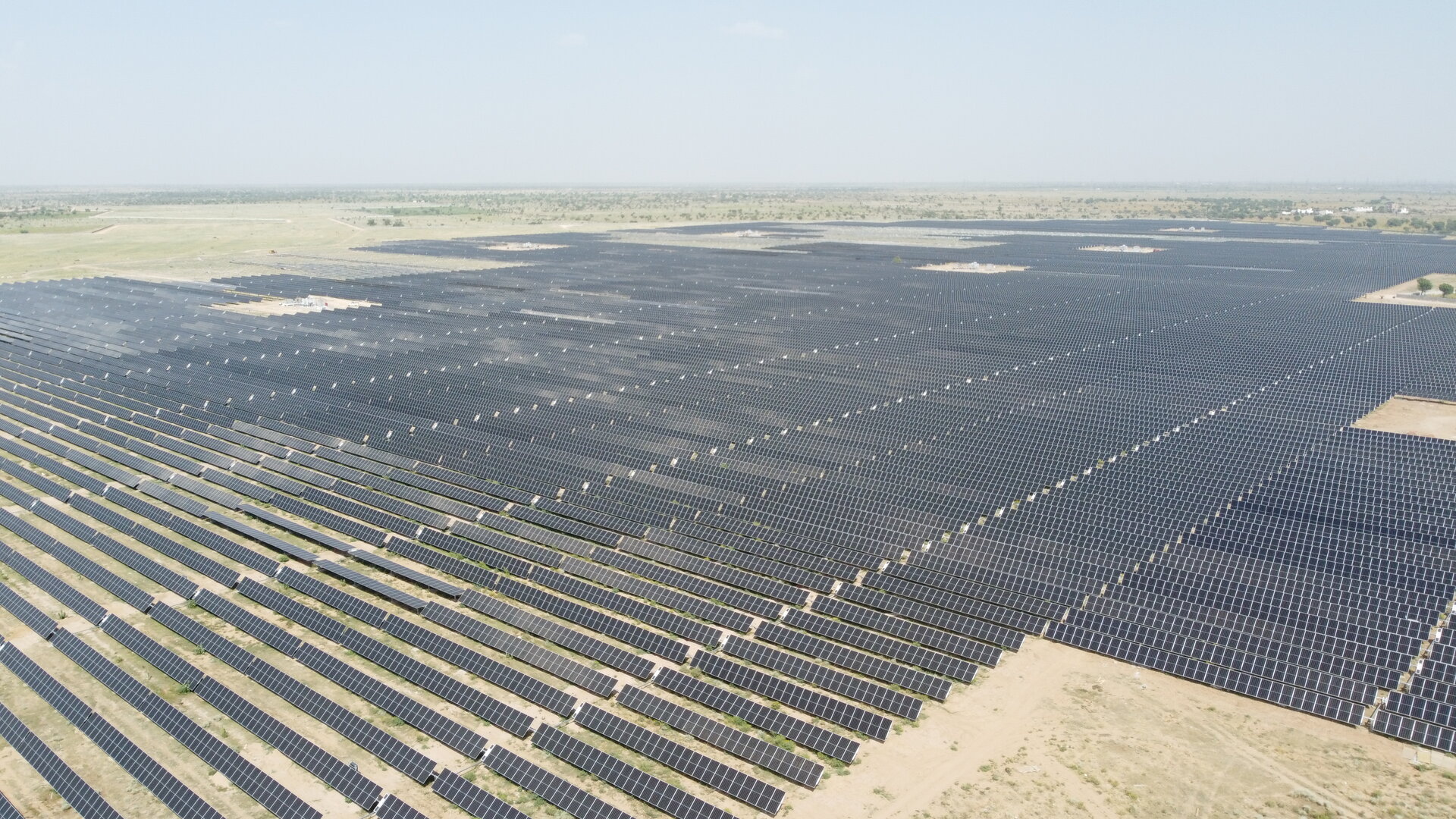 Aerial view of a large-scale solar photovoltaic power plant in a desert setting, representing the renewable energy infrastructure powering NEOM green hydrogen production