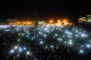 Thousands of Sudanese protesters hold phone lights during a nighttime sit-in demonstration in Khartoum, Sudan. Photo: Wikimedia Commons / CC BY-SA 4.0